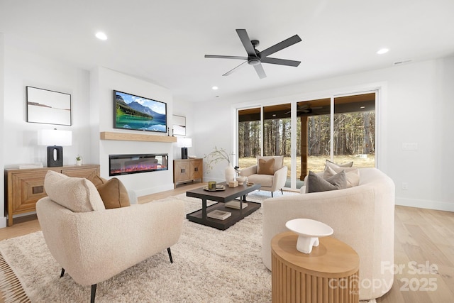 living room with ceiling fan and light wood-type flooring