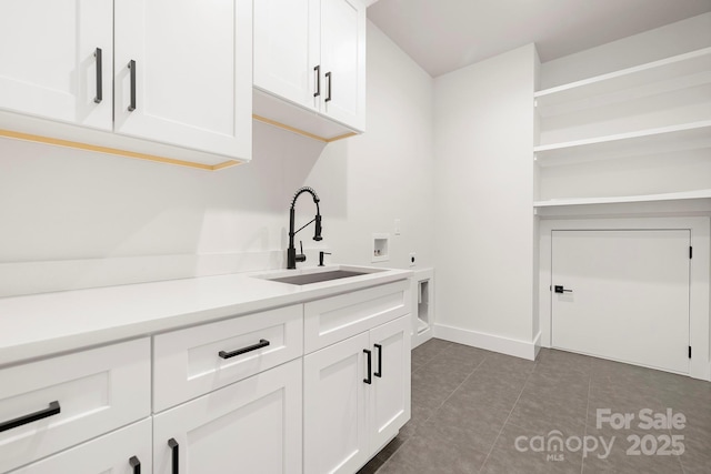 interior space featuring sink, white cabinets, and dark tile patterned flooring