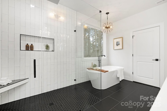 bathroom with tile patterned flooring, independent shower and bath, and an inviting chandelier