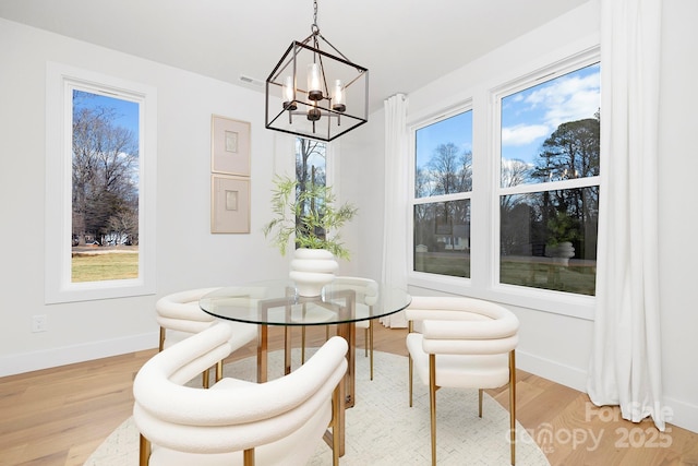 dining area with a chandelier and light hardwood / wood-style floors