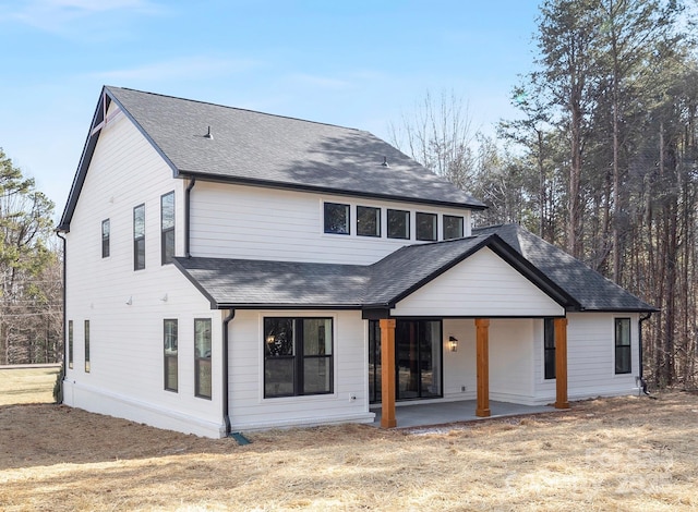 rear view of house featuring a lawn and a patio area