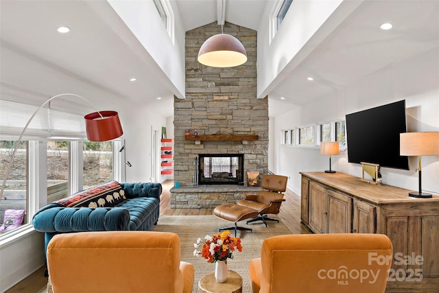 living room with a stone fireplace, light hardwood / wood-style flooring, and vaulted ceiling with beams