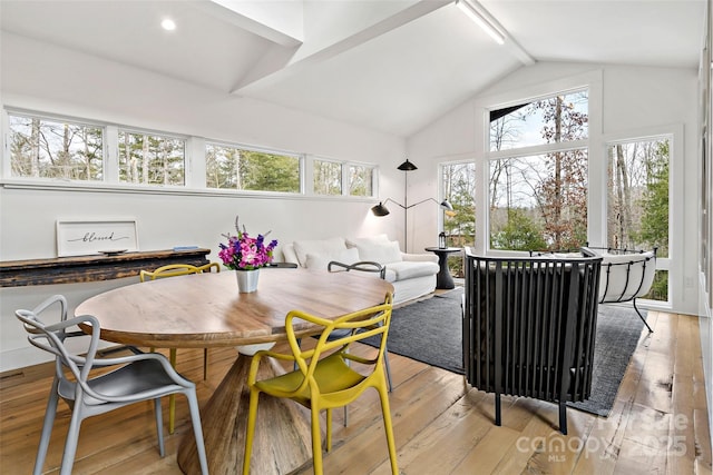 dining space featuring lofted ceiling and light hardwood / wood-style flooring