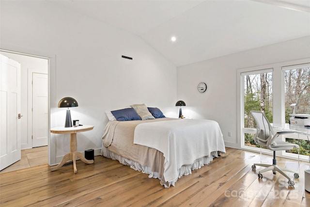 bedroom with lofted ceiling and light wood-type flooring