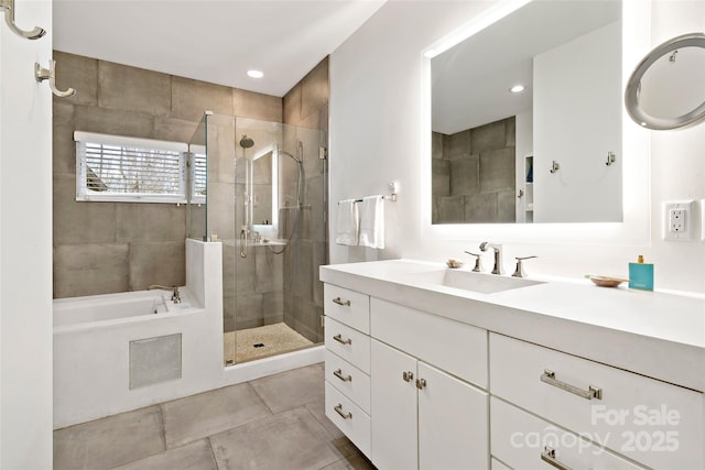 bathroom with vanity and shower with separate bathtub