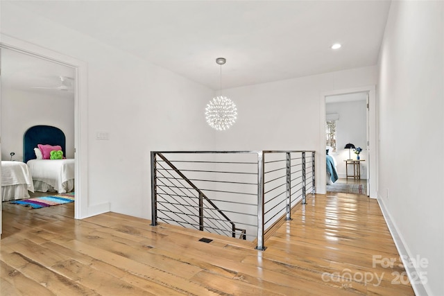 hall with hardwood / wood-style flooring and a notable chandelier