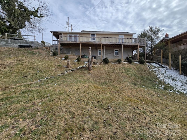 back of house with a wooden deck and a lawn