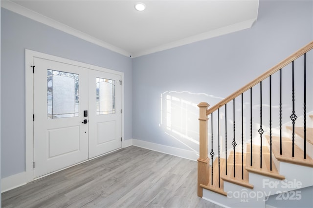 foyer featuring french doors, ornamental molding, and light hardwood / wood-style flooring