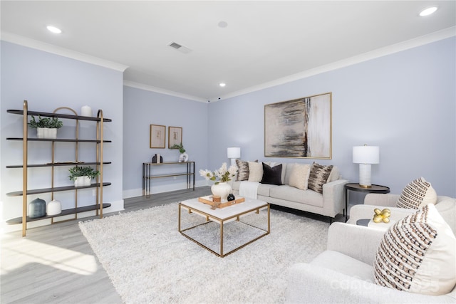 living room with ornamental molding and light hardwood / wood-style floors