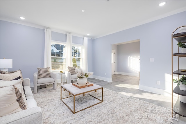 living room with crown molding and light hardwood / wood-style floors