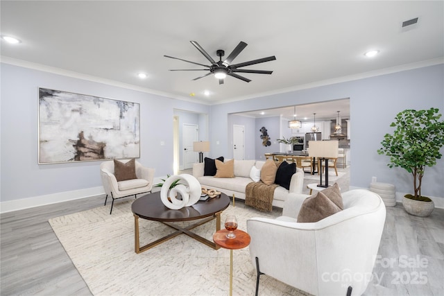 living room with wood-type flooring, ornamental molding, and ceiling fan