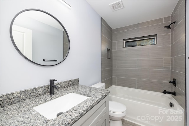 full bathroom featuring tiled shower / bath combo, vanity, and toilet