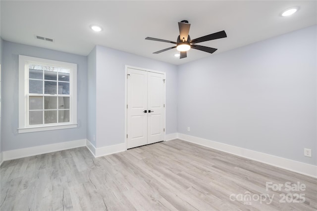 unfurnished bedroom featuring light hardwood / wood-style flooring, ceiling fan, and a closet