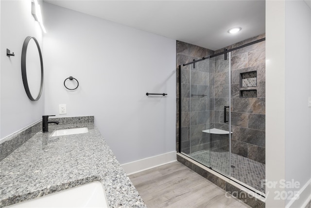 bathroom featuring vanity, a shower with shower door, and wood-type flooring