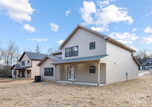 rear view of house with central AC and a patio area