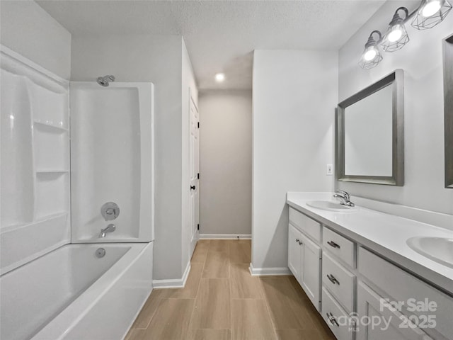 bathroom with vanity, shower / bathing tub combination, and a textured ceiling