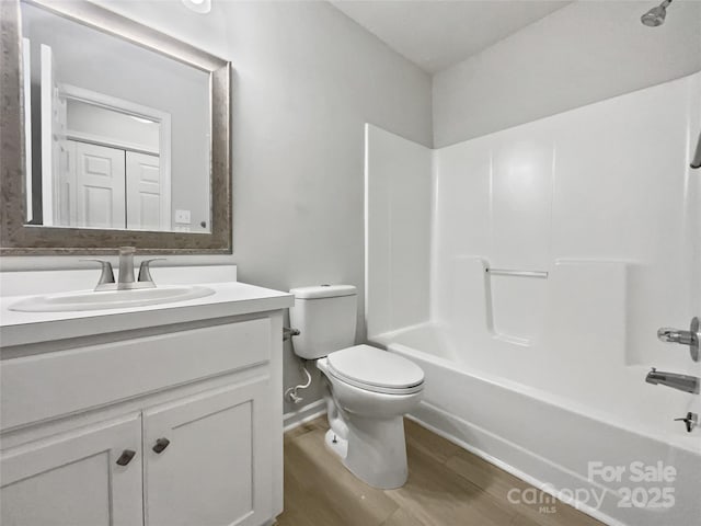 full bathroom featuring vanity, hardwood / wood-style floors, shower / washtub combination, and toilet