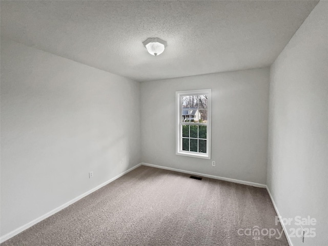 carpeted spare room featuring a textured ceiling