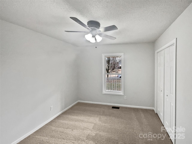 unfurnished bedroom with carpet floors, a textured ceiling, and ceiling fan