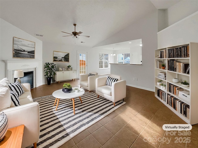 living room with dark tile patterned floors, lofted ceiling, and ceiling fan