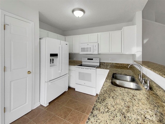 kitchen featuring sink, white appliances, dark stone countertops, a textured ceiling, and white cabinets