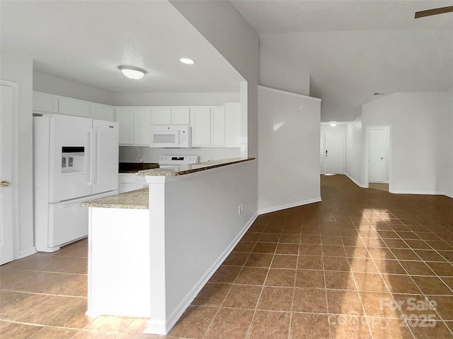 kitchen with white appliances, white cabinetry, light stone counters, tile patterned floors, and kitchen peninsula