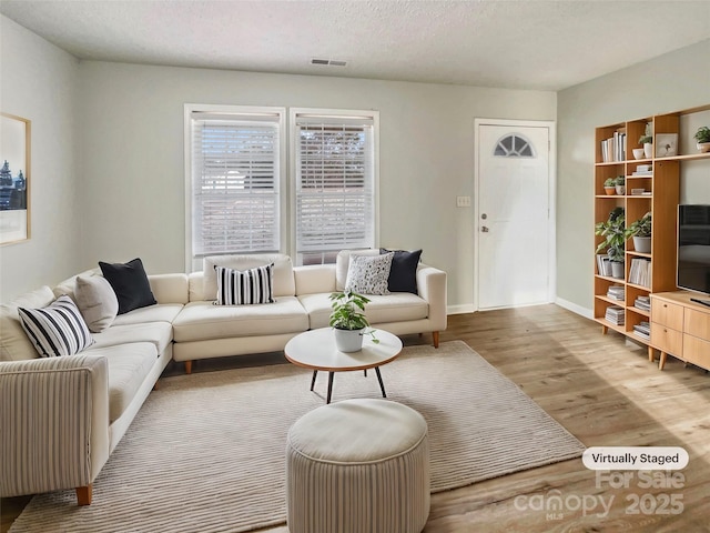 living room featuring light hardwood / wood-style floors and a textured ceiling