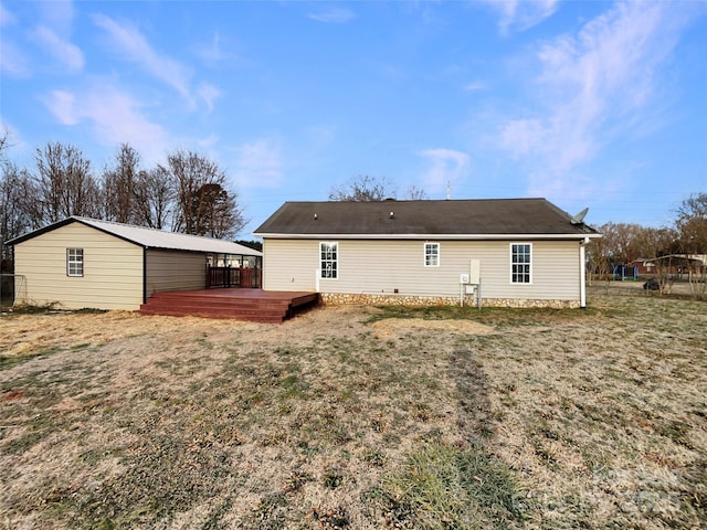 rear view of house with a wooden deck and a lawn