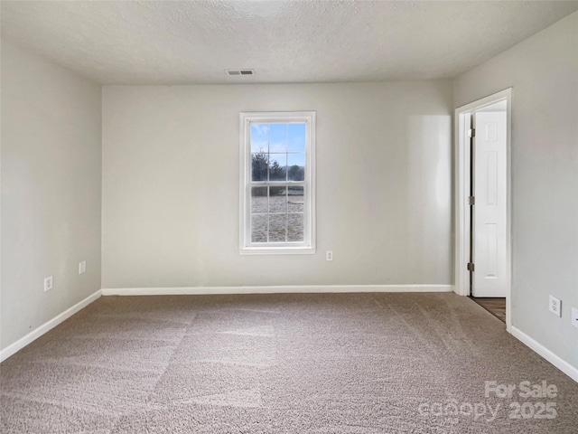 carpeted spare room featuring a textured ceiling