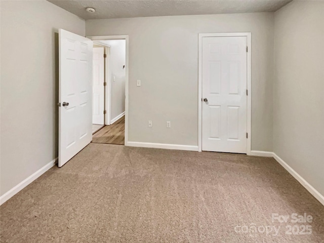 unfurnished bedroom with a textured ceiling and carpet flooring