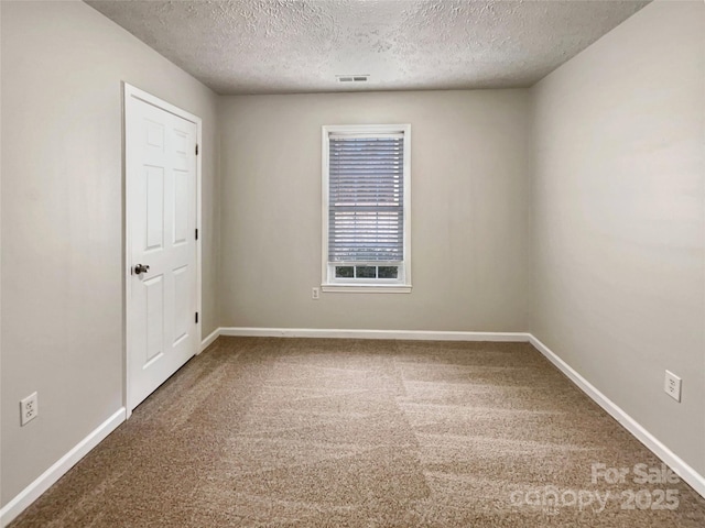 carpeted spare room featuring a textured ceiling