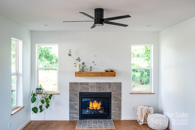 living room with hardwood / wood-style flooring and a tiled fireplace