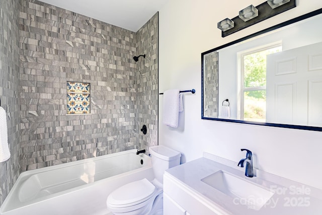 full bathroom with tiled shower / bath, vanity, and toilet