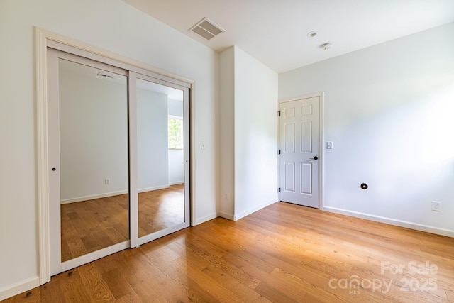 unfurnished bedroom featuring wood-type flooring and a closet