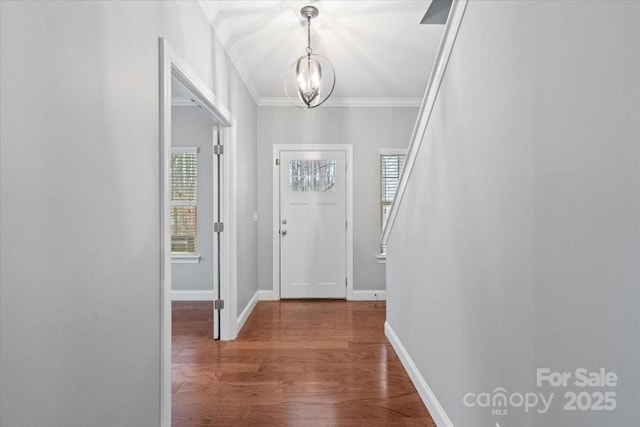 entryway featuring ornamental molding, a chandelier, and wood-type flooring