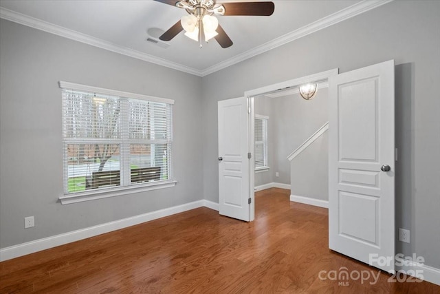 unfurnished room with hardwood / wood-style floors, crown molding, and ceiling fan