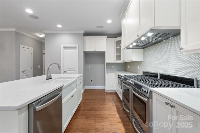 kitchen featuring sink, tasteful backsplash, white cabinetry, appliances with stainless steel finishes, and ornamental molding