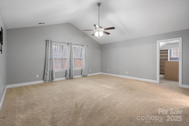 carpeted spare room with ceiling fan and vaulted ceiling