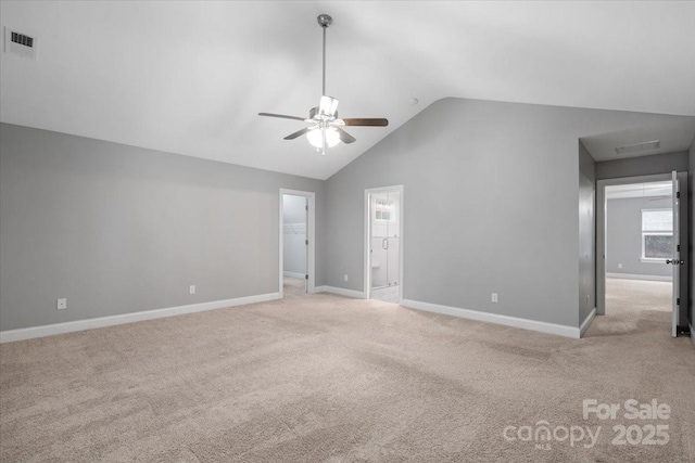 empty room featuring light carpet, vaulted ceiling, and ceiling fan