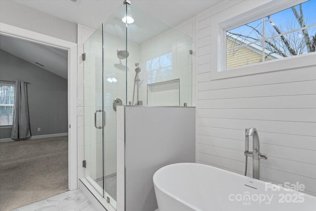 bathroom featuring a wealth of natural light and shower with separate bathtub