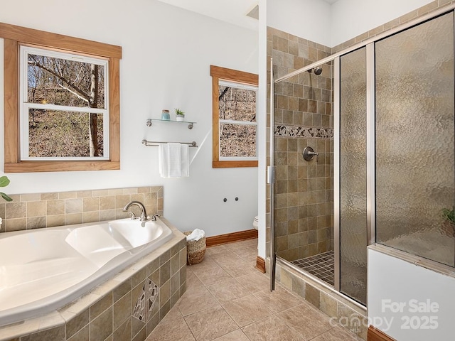 bathroom featuring tile patterned flooring, a garden tub, a shower stall, and toilet