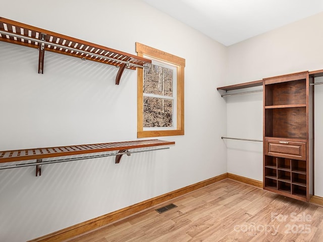 walk in closet featuring light wood-style flooring and visible vents