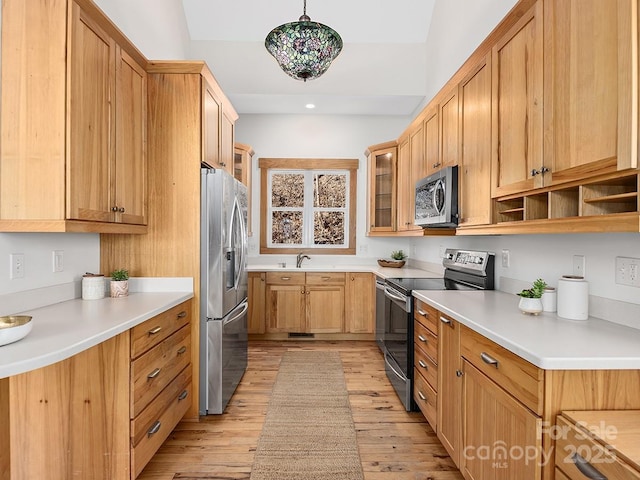 kitchen featuring stainless steel appliances, light countertops, light wood-type flooring, open shelves, and glass insert cabinets