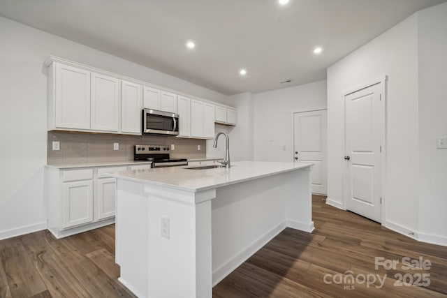 kitchen featuring a kitchen island with sink, sink, white cabinets, and appliances with stainless steel finishes