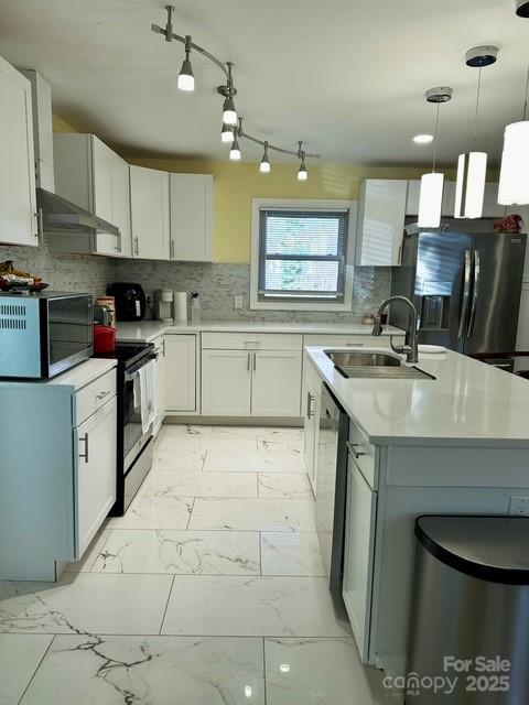 kitchen with an island with sink, a sink, stainless steel appliances, light countertops, and marble finish floor