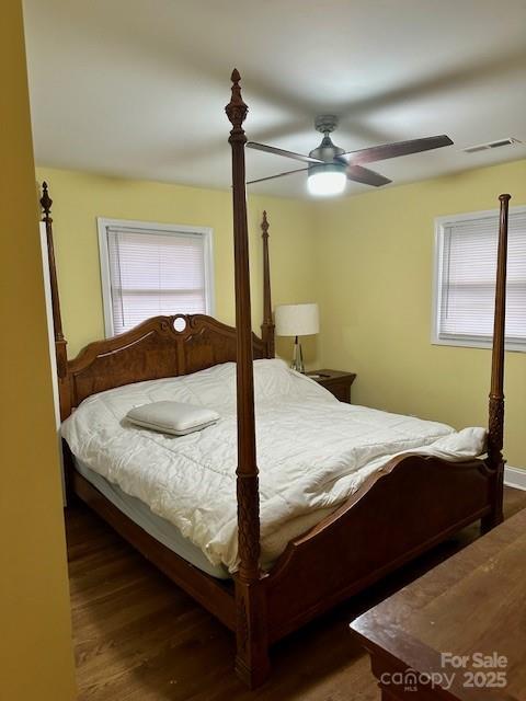 bedroom with visible vents, multiple windows, wood finished floors, and a ceiling fan