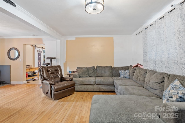 living room with crown molding, a barn door, and hardwood / wood-style floors