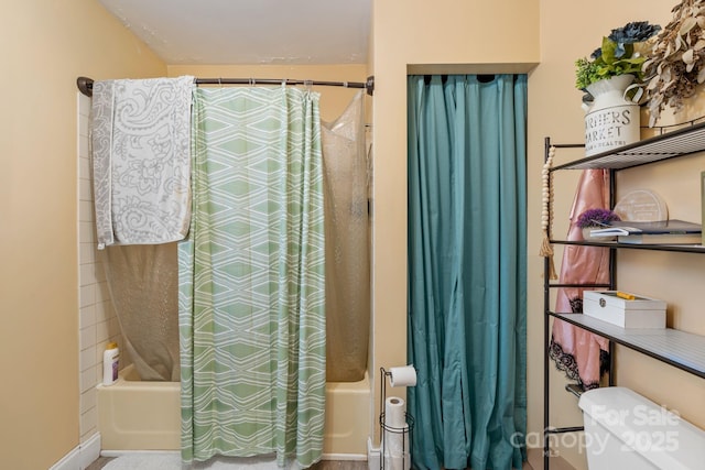 bathroom with toilet and shower / bath combo with shower curtain