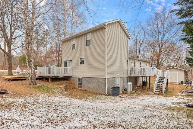 back of house with a storage unit, central air condition unit, and a deck