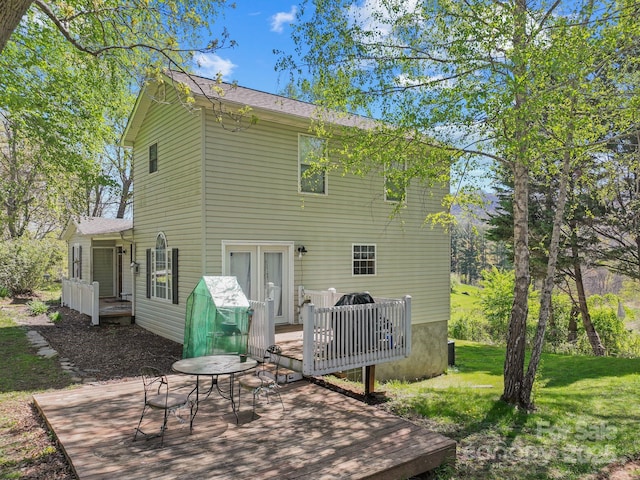 back of house featuring a yard and a deck